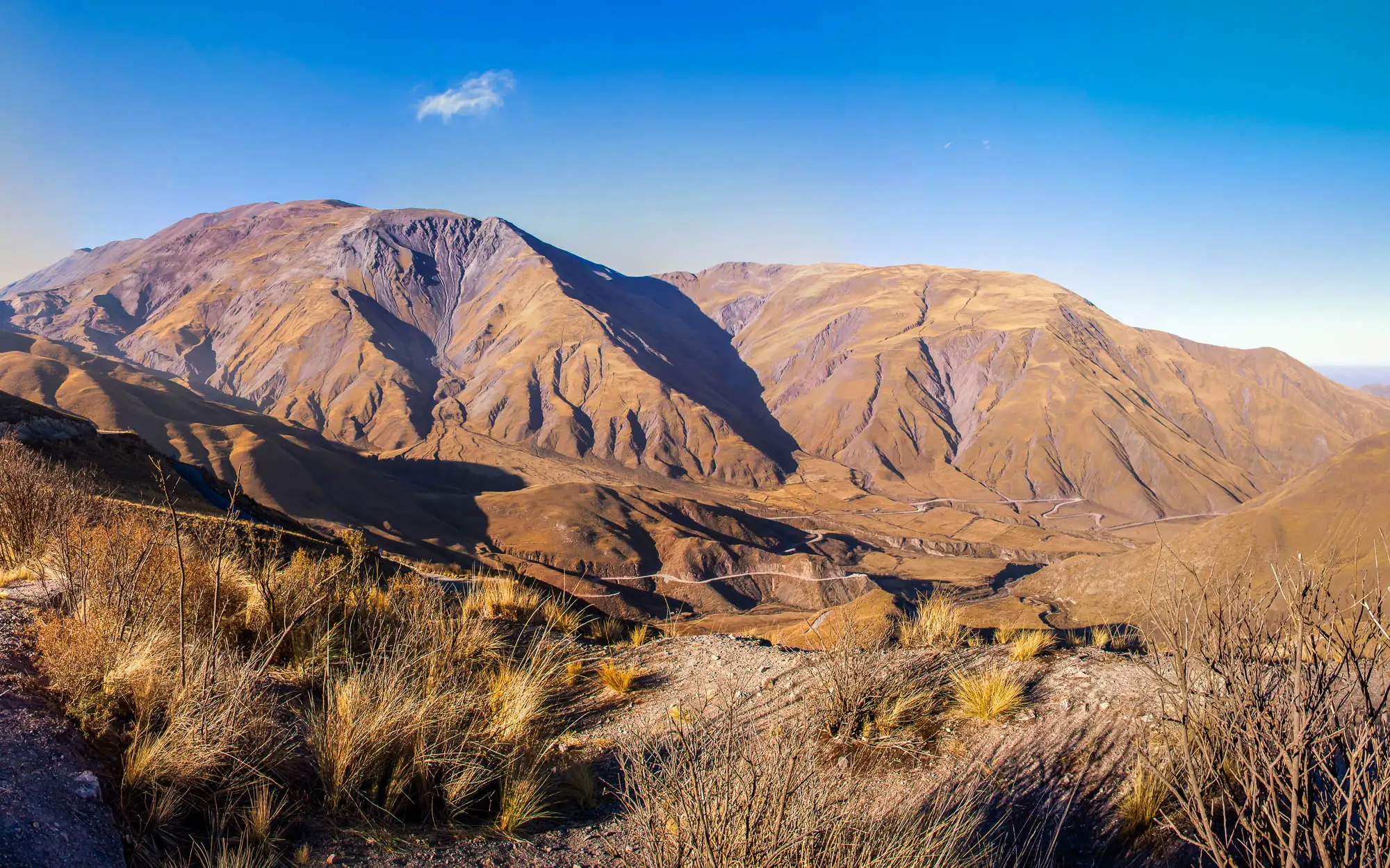 Imagen decorativa. Paisaje de un valle árido con montañas de fondo.