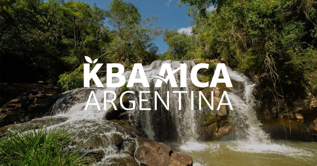 Logotipo de KBA AICA Argentina sobre un fondo fotográfico de un paisaje del Parque Provincial Salto Encantado del Valle del Cuñá-Pirú y alrededores.